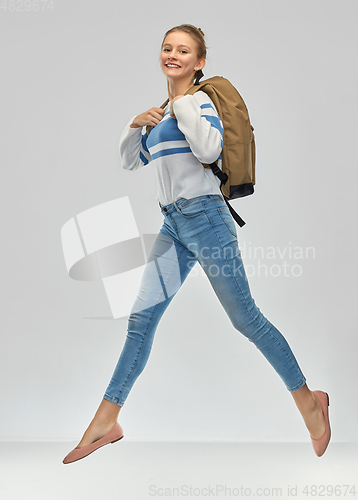 Image of happy teenage student girl with school bag jumping