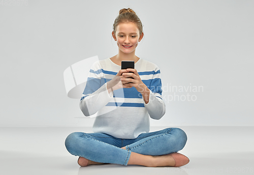 Image of happy smiling teenage girl using smartphone