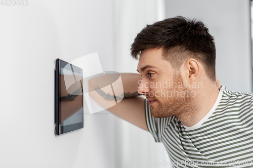 Image of man looking at tablet computer at smart home