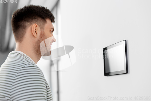 Image of happy man looking at tablet computer at smart home