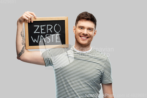 Image of smiling man holding chalkboard with zero waste