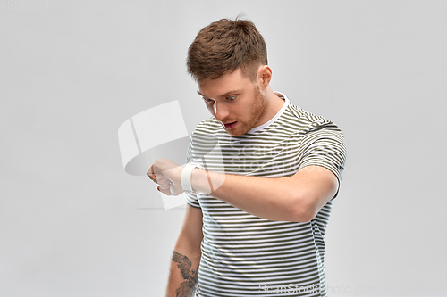 Image of surprised young man looking at smart watch