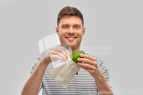 Image of smiling man with avocado in reusable canvas bag