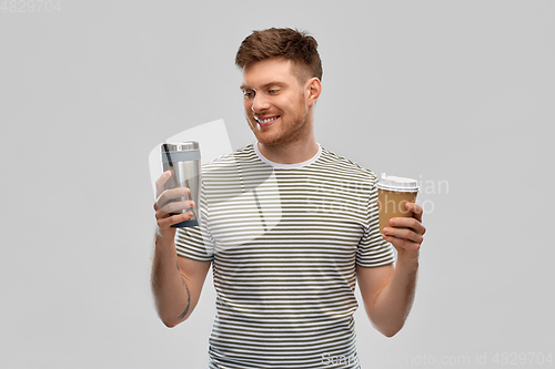 Image of man comparing thermo cup or tumbler and coffee cup