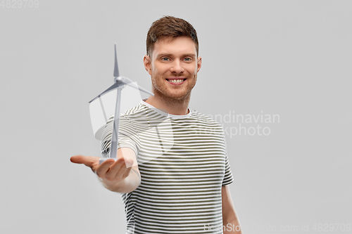 Image of smiling young man with toy wind turbine