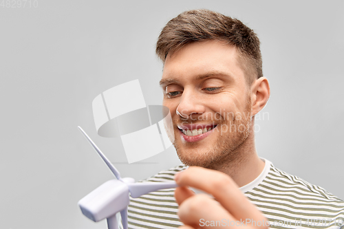 Image of smiling young man with toy wind turbine