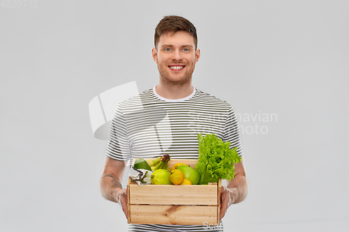 Image of happy smiling man with food in wooden box
