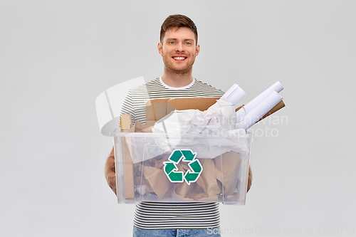 Image of smiling young man sorting paper waste