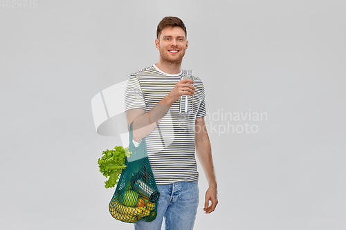 Image of man with food in bag and water in glass bottle