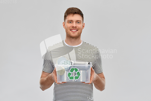 Image of smiling young man sorting metallic waste