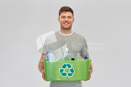 Image of smiling young man sorting plastic waste