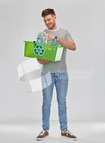 Image of smiling young man sorting plastic waste