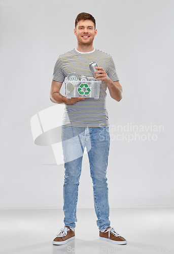 Image of smiling young man sorting metallic waste