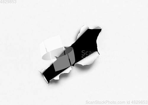 Image of White torn paper with black hole