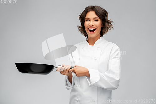 Image of smiling female chef in toque with frying pan