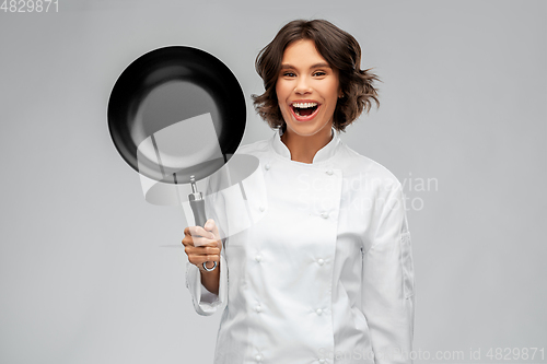 Image of smiling female chef in toque with frying pan