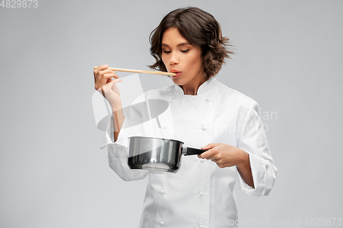 Image of female chef with saucepan tasting food