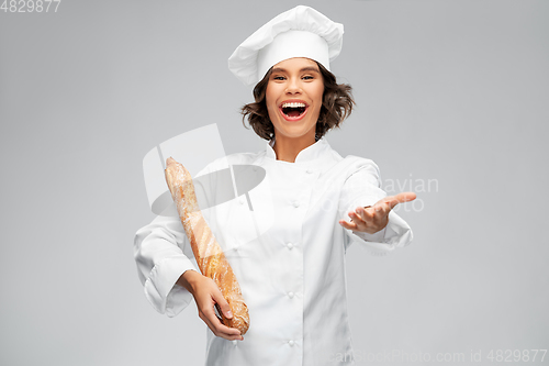 Image of happy female chef with french bread or baguette