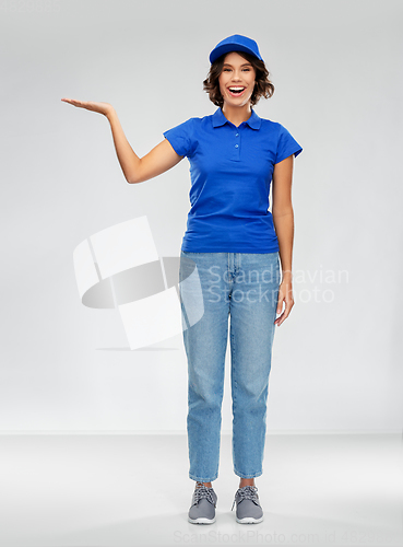 Image of happy smiling delivery woman in blue uniform