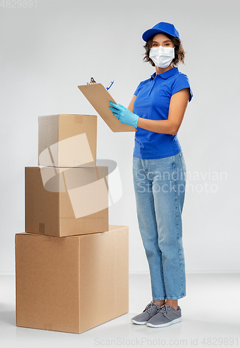 Image of delivery woman in mask with boxes and clipboard