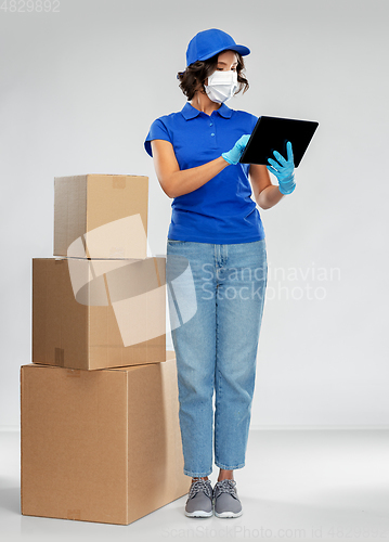 Image of delivery woman in mask with boxes and tablet pc