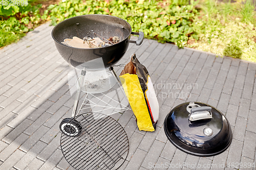 Image of bbq grill brazier and bag of charcoal outdoors