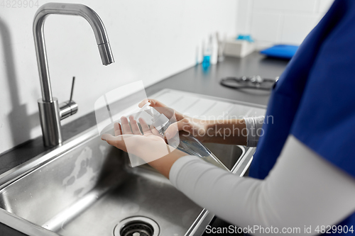 Image of doctor or nurse washing hands with liquid soap