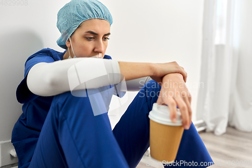 Image of sad doctor or nurse with cup of takeaway coffee
