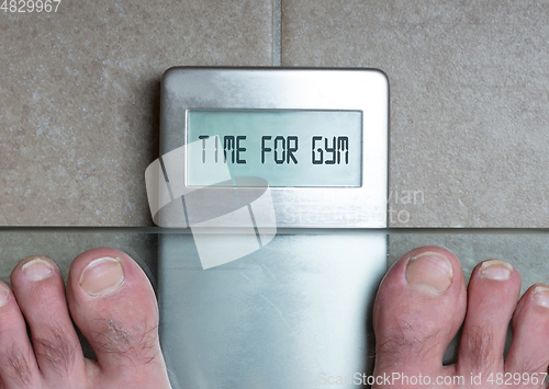 Image of Man\'s feet on weight scale - Time for gym