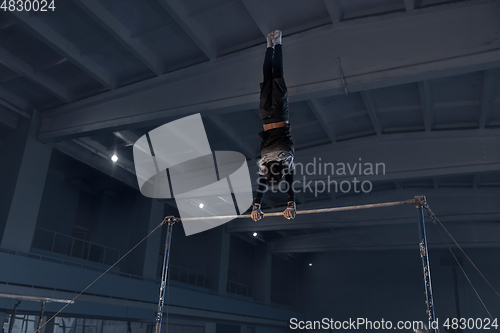 Image of Little male gymnast training in gym, flexible and active