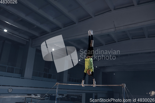 Image of Little male gymnast training in gym, flexible and active