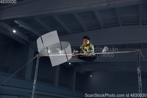 Image of Little male gymnast training in gym, flexible and active