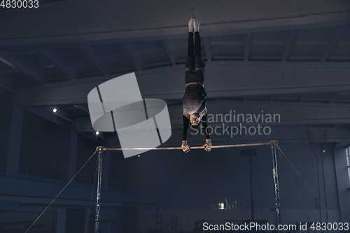 Image of Little male gymnast training in gym, flexible and active