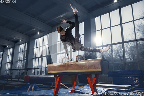 Image of Little male gymnast training in gym, flexible and active