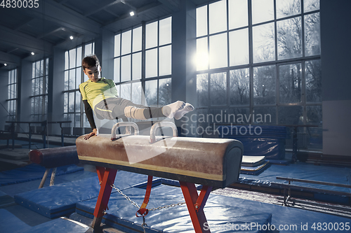 Image of Little male gymnast training in gym, flexible and active