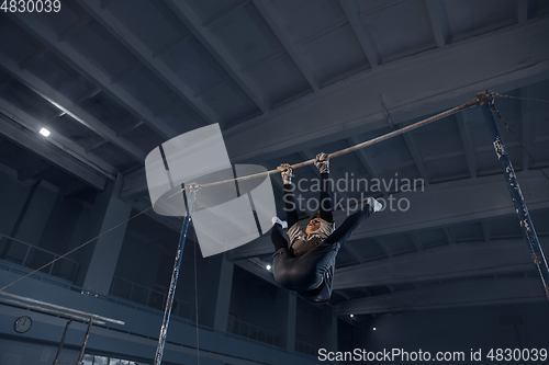 Image of Little male gymnast training in gym, flexible and active