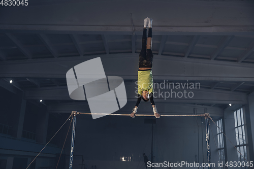 Image of Little male gymnast training in gym, flexible and active