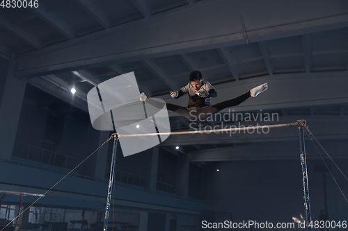 Image of Little male gymnast training in gym, flexible and active