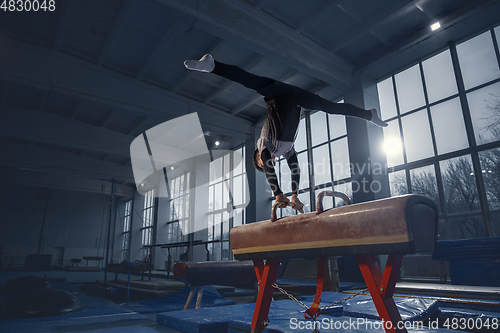 Image of Little male gymnast training in gym, flexible and active