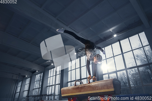 Image of Little male gymnast training in gym, flexible and active