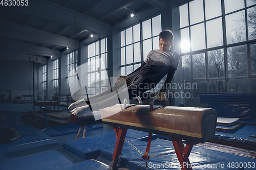 Image of Little male gymnast training in gym, flexible and active