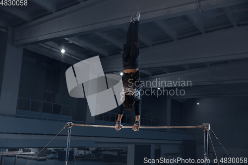 Image of Little male gymnast training in gym, flexible and active