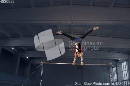 Image of Little male gymnast training in gym, flexible and active