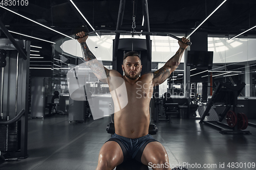 Image of The male athlete training hard in the gym. Fitness and healthy life concept.