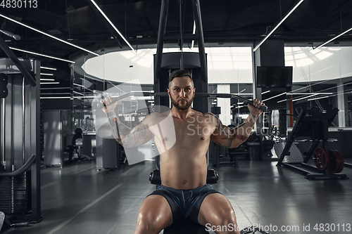 Image of The male athlete training hard in the gym. Fitness and healthy life concept.