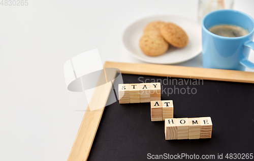 Image of chalkboard with stay at home words on toy blocks
