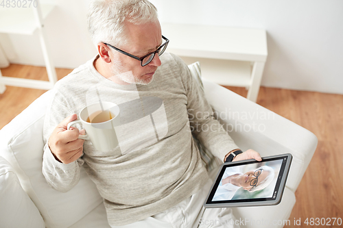 Image of old man with tablet pc has video call with woman