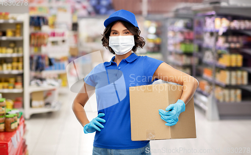 Image of delivery woman in face mask holding box at store