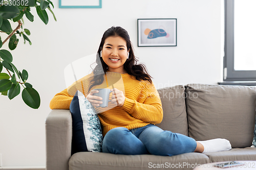 Image of woman in earphones listening to music at home