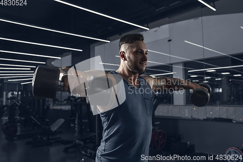 Image of The male athlete training hard in the gym. Fitness and healthy life concept.